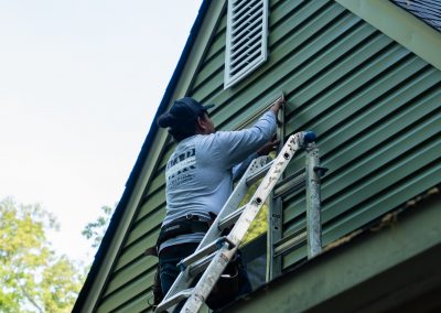 employee replacing window treatment